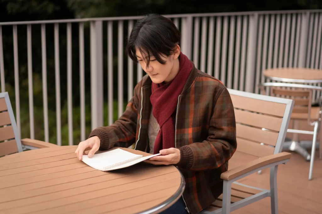 a side view man reading book on how to learn kanji fast