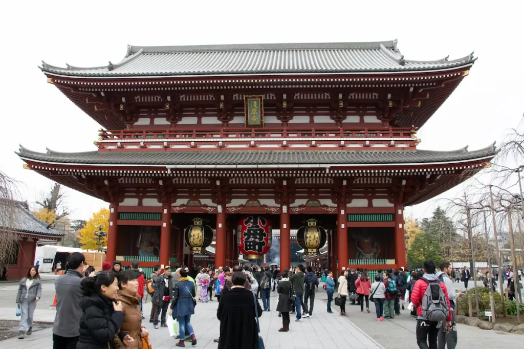 Tourists exploring Senso-ji Temple in Tokyo, Japan, a popular cultural site where visitors can practice Japanese etiquette for tourists, such as respectful bowing, proper shrine manners, and maintaining quiet decorum.